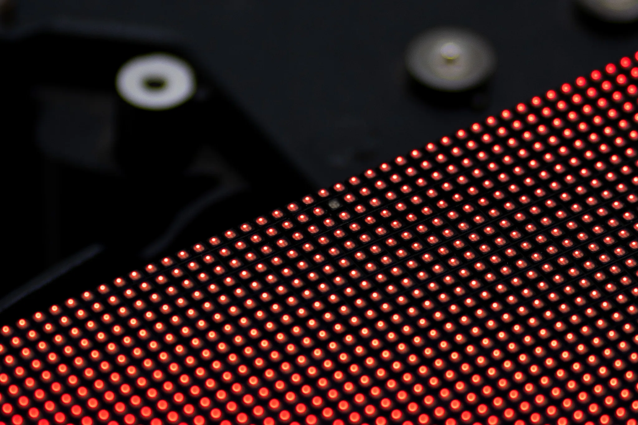 Close-up of glowing red LEDs on an LED display module with mounting hardware visible in the background
