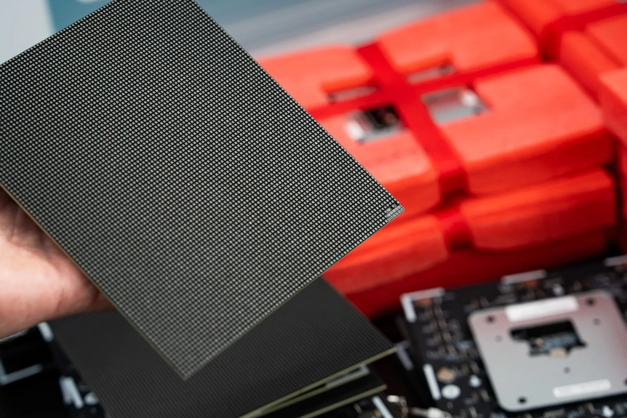 Hand holding a fine pitch LED module with its pixel grid filling the frame