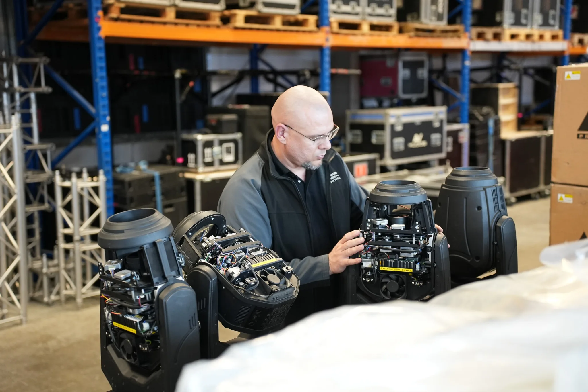 Technician finishing checks on a group of moving head lights during an on site warehouse visit